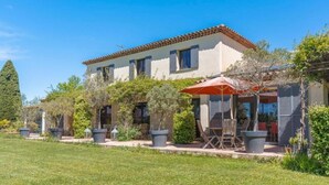 A two-story house with a tiled roof, a patio with outdoor furniture, and a well-maintained garden. - Villa Aix-en-Provence Piscine et calme absolu (paris)