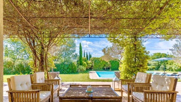 A covered outdoor seating area with a pool in the background. - Villa Aix-en-Provence Piscine et calme absolu (paris)