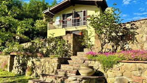 A two-story house with a stone staircase leading to a balcony. - Milu's Holiday Home (Toscana)