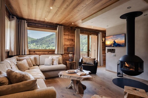 A cozy living room with a sofa, a coffee table, and a fireplace.