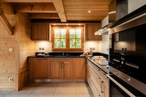 A modern kitchen with wooden cabinets, a black countertop, and stainless steel appliances.