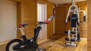A gym with an exercise bike, a stationary bike, and weightlifting equipment.
