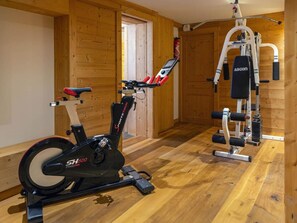 Ein Fitnessstudio mit Ergometer, Hanteln und Krafttrainingsgeräten.