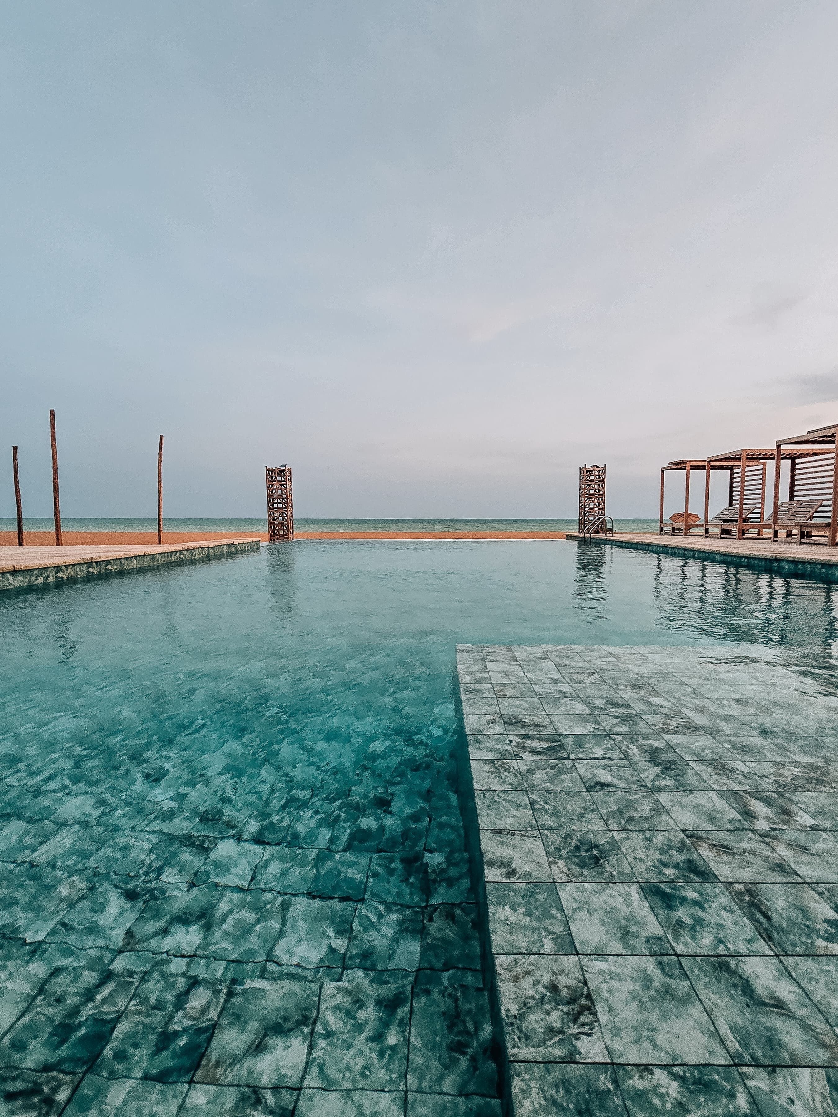 Una piscina al aire libre, sillones reclinables de piscina