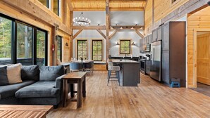 A spacious kitchen with modern appliances and a dining area with a sofa and tables.