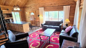 A cozy cabin interior with a living room, a dining area, and a kitchen. - Authentic Log Cabin w/ fire pit - 45 Mins to Yellowstone! (Island Park)