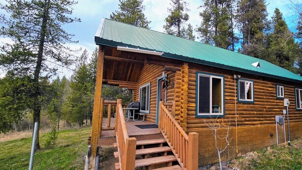 A log cabin with a porch, a table, and a bench. - Authentic Log Cabin w/ fire pit - 45 Mins to Yellowstone! (Island Park)