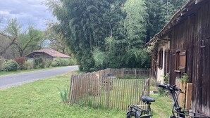 A green electric bike parked near a wooden fence and a rustic building. - Charming cabin by a lake in the heart of the Landes d'Armagnac forest (Losse)
