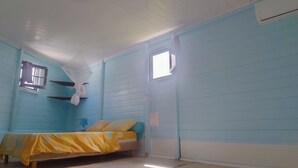 Quarto com uma cama, janela e ventilador de teto.