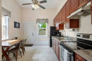 Enjoy meals in this kitchen with a dining table, refrigerator, stove, and sink.