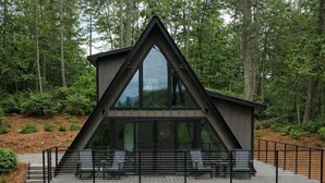 A modern cabin with a large deck, two seating areas, and a staircase leading to the entrance. - Riverfront A-Frame Cabin in the Mountains w/ Sauna & Private Hiking Trail (Ellijay)