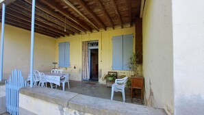 A covered outdoor area with a table and chairs, a wooden ceiling, and a door leading inside. - Typical Tarn et Garonne farmhouse, ideal for a large family. (Canals)