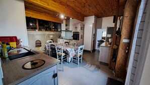 A modern kitchen with a wooden ceiling, a dining area with a patterned tablecloth, and a small island with a sink. - Typical Tarn et Garonne farmhouse, ideal for a large family. (Canals)