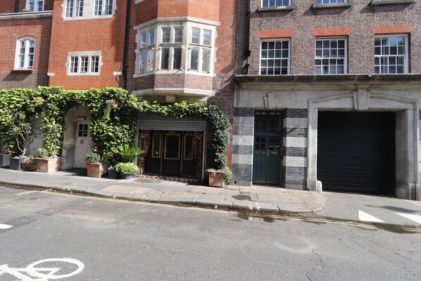 A building with a corner entrance, a garage door, and a bicycle lane.