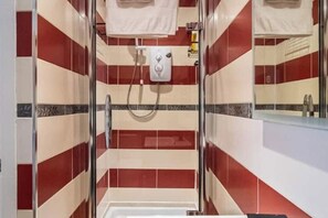 Chuveiro, toalhas de banho, shampoo, papel higiênico