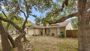 A single-story house with a sloped roof, a front porch, and a covered patio area. - Private San Antonio Getaway Near SeaWorld! (San Antonio)