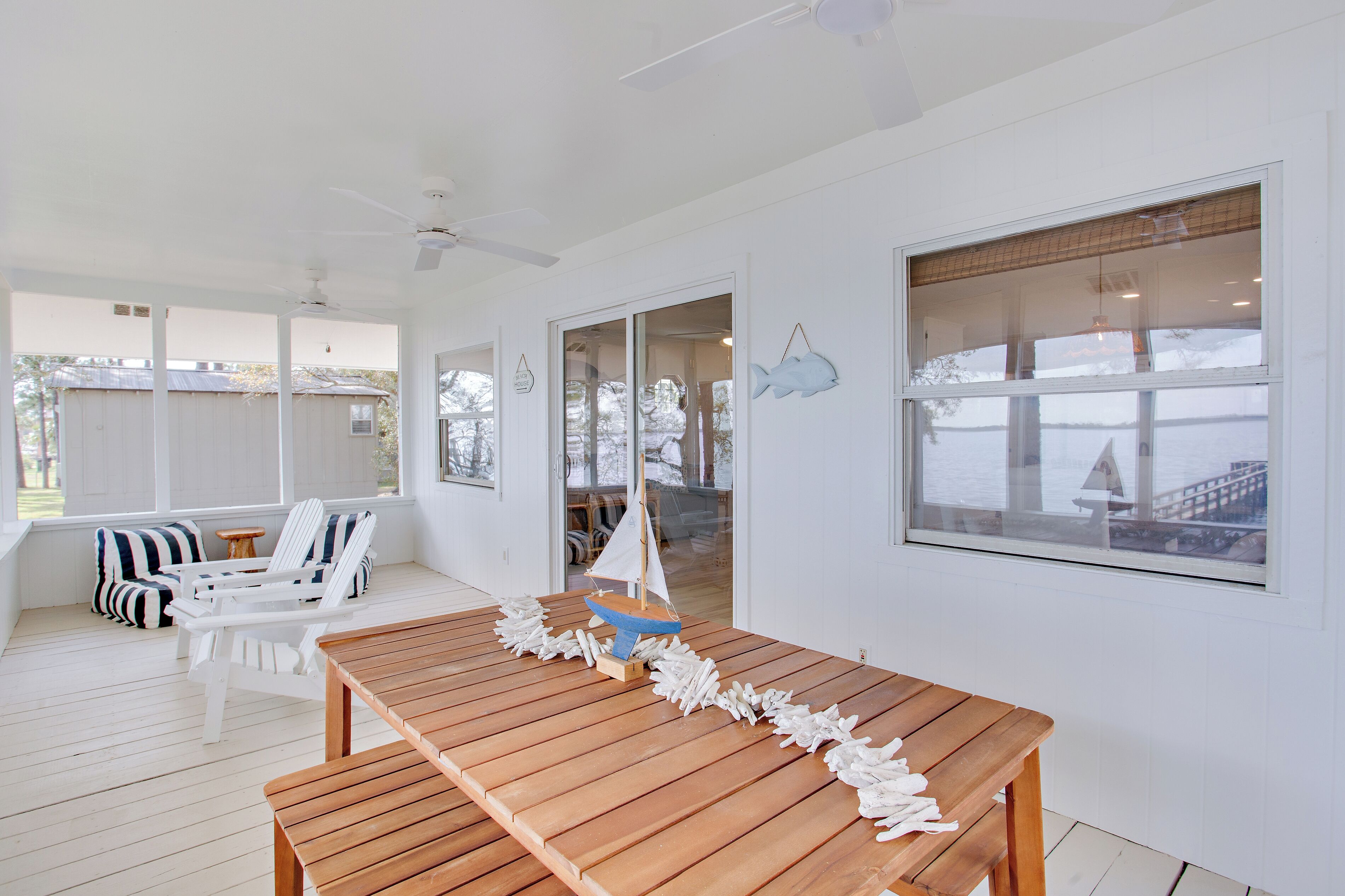 A spacious room with a wooden table, white chairs, and a sailboat model.
