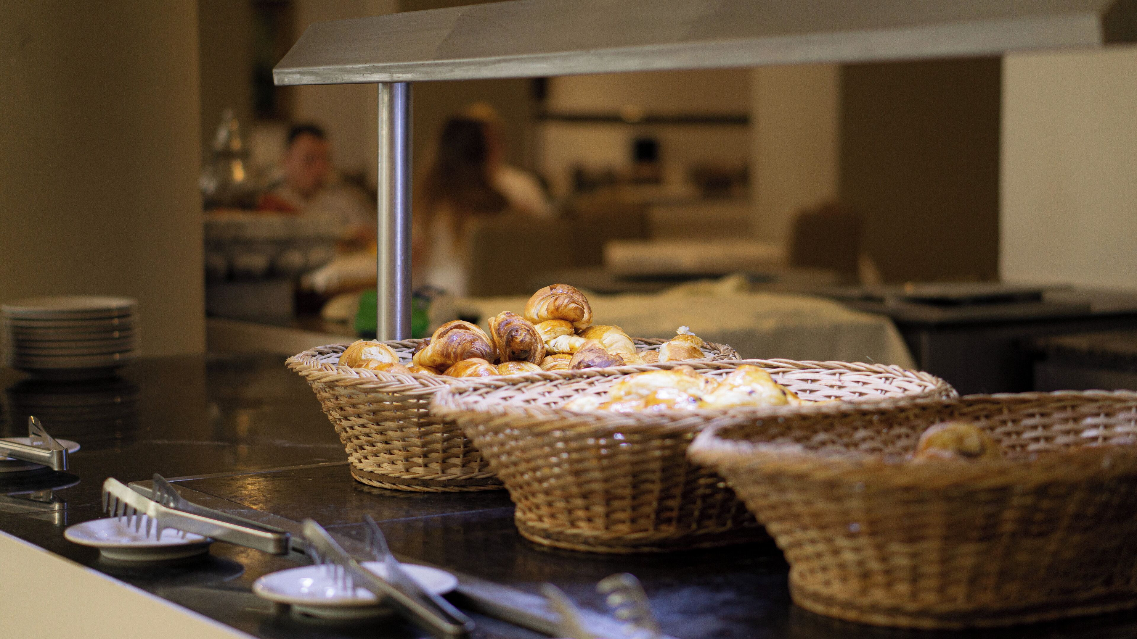 Cestas de pasteles sobre una mesa de buffet con un soporte metálico encima.