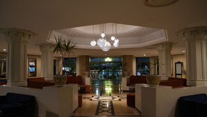 A spacious lobby with a central chandelier, seating areas, and large windows. - Golf Residence- Family Only (Port El Kantaoui)