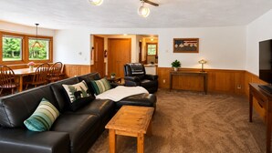 Ein Wohnzimmer mit Ledersofa, Couchtisch aus Holz und einem Fernsehmöbel.