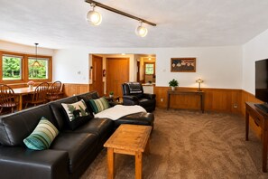 Un salon avec un canapé en cuir, une table basse en bois et un meuble pour la télévision.