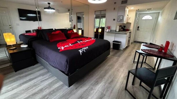 Une chambre à coucher moderne avec un lit, des tables de chevet, un bureau et une chaise.
