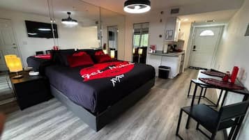 Un dormitorio moderno con cama, mesitas de noche, un escritorio y una silla.