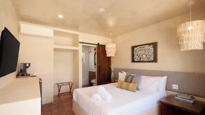 Una habitación de hotel con cama, mesita de noche y televisión.