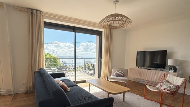 A modern living room with a sofa, coffee table, and a TV.