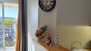 Eine Küche mit Holzarbeitsplatte, einer Uhr und einer Obstschale.