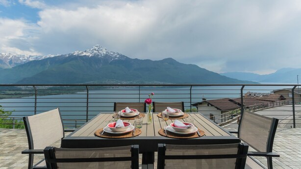 Une table dressée pour deux personnes, avec une vue sur les montagnes en arrière-plan.