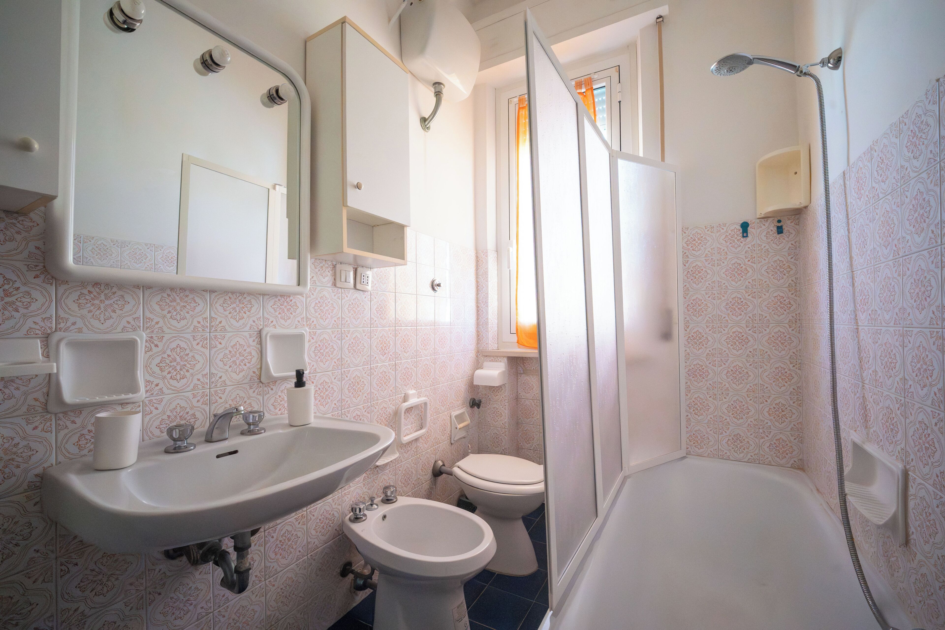 Une salle de bain équipée d’un lavabo, d’un bidet, de toilettes et d’une douche.