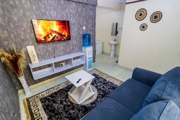 Deluxe-Apartment, Stadtblick | Wohnbereich | 24-Zoll-Smart-TV mit Digitalempfang