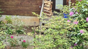A wooden cabin with a front door, a nameplate reading "Donna's 16", and a stack of firewood outside.
