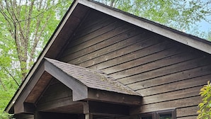 A rustic wooden cabin with a porch, a small attached shed, and a sign reading "Gracie's Willow".