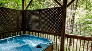 A hot tub on a wooden deck with a view of a forest. - Trade the Hotel for a Hot Tub During PGA TOUR Asheville (Asheville)