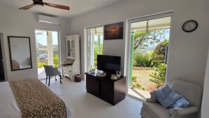 A hotel room with a bed, a desk, a TV, and a view of the outdoors. - 5 Bedroom, luxury private villa with pool & 360' ocean views (Gros Islet)