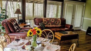 Un comedor con una mesa dispuesta para cuatro personas, rodeado de sofás de cuero y un plaid estampado.