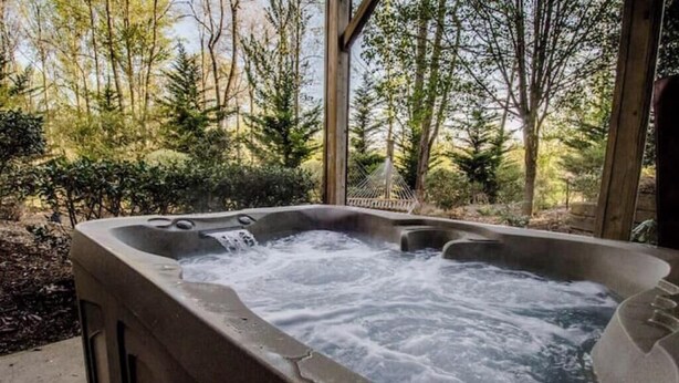 A hot tub in an outdoor setting surrounded by trees. - Romantic getaway w/hot tub (Asheville)