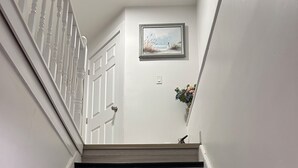 A staircase with wooden steps and white walls.