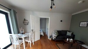 A spacious living area with a dining table and chairs, a sofa, and a coffee table. - The Annex @ Holly Glenn a cosy couple's retreat (Clint Green)