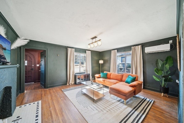 A living room with a sofa, a coffee table, a lamp, and a potted plant.