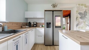 Una cocina moderna con armarios blancos, electrodomésticos de acero inoxidable y encimera de madera.