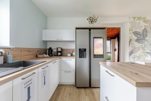 A modern kitchen with white cabinets, stainless steel appliances, and a wooden countertop. - House for 10 | Garden, Pool & Cinema | 20 min Europa-Park (Witternheim)