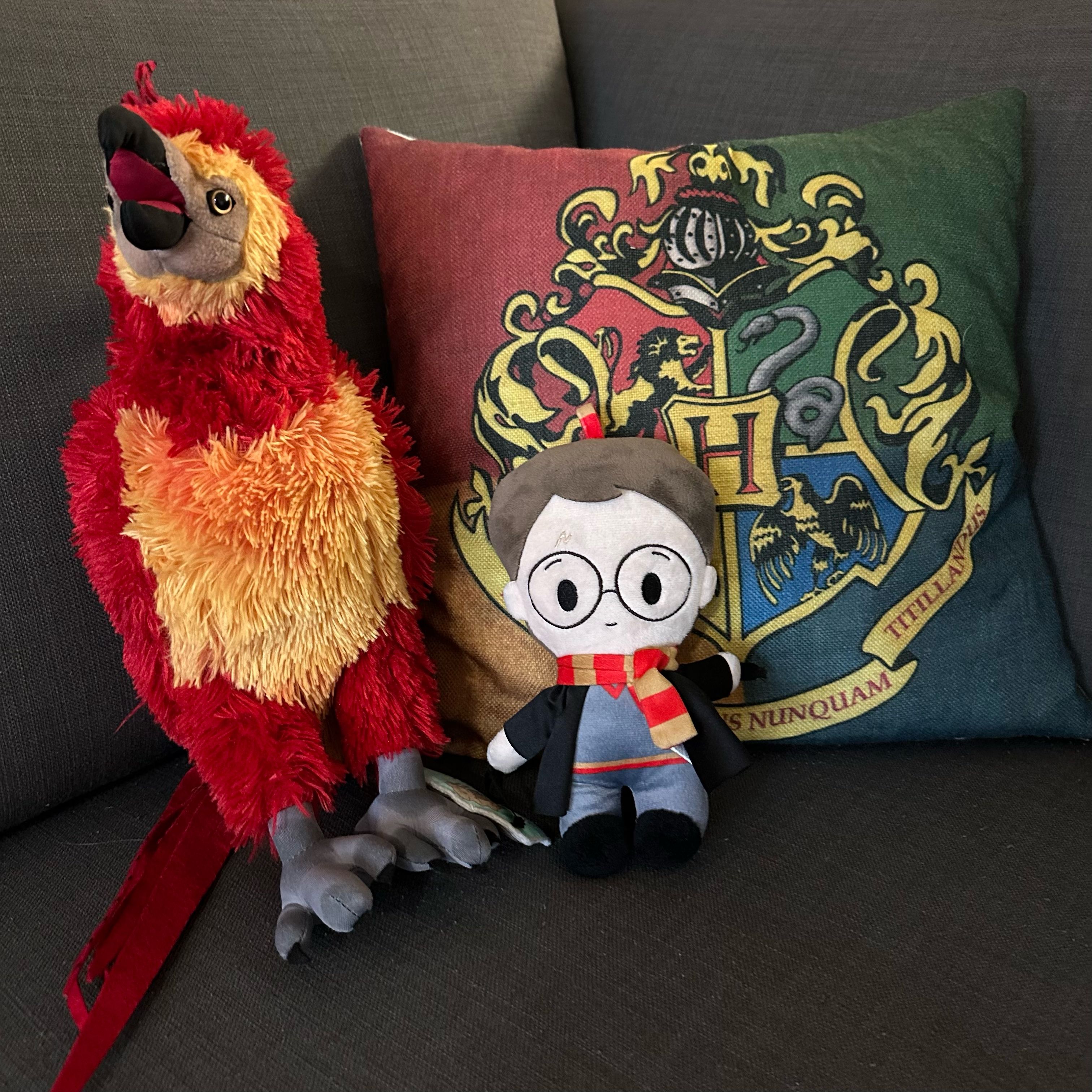 Un peluche y una almohada con un escudo sobre un sofá.