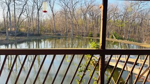 Vista de un lago con un muelle de madera y una baranda de madera al frente.