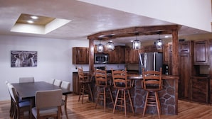 Una cocina moderna con armarios de madera, una isla de piedra y taburetes de bar.