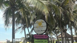 A directional signpost with multiple arrows pointing to amenities such as a reception, bodega, sauna, spa, and restaurant.