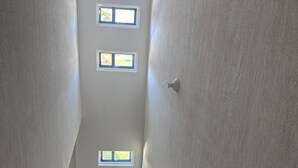 A staircase with a textured wall and multiple windows allowing natural light.