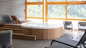 A spa area with a hot tub, wooden steps, and seating. - Chalet in Vaujany With Panoramic Mountain Views (Vaujany)